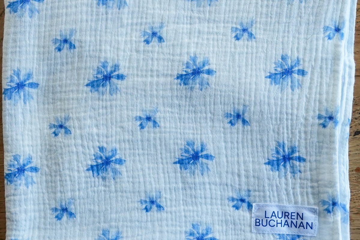 Cornflower muslin swaddle on an oak table
