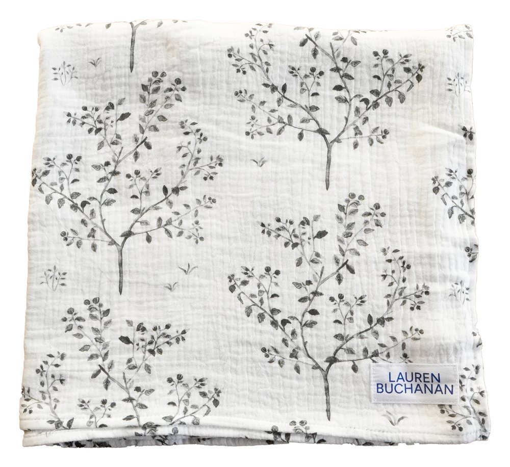 Muslin swaddle blanket in Snowberry, folded, with grey snowberry branches painted on white cloth